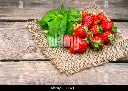 strawberries with fresh mint leaves on wooden background. country style picture. selective focus Stock Photo