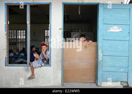 Tacloban, Philippines. 11th June, 2014. Students pose for a picture in San Jose Central School, Tacloban City on June 11, 2014. On November 8, 2013, Haiyan, one of the most powerful typhoon to ever hit land, ravaged Eastern Visayas leaving thousands dead and homeless. Government estimates 16 million people to have been affected by the typhoon, with 6,300 reported dead and thousands more missing. Housing and livelihood are among the serious challenges in the rehabilitation process in Haiyan-affected areas seven months after the disaster. © Mark Cristino/NurPhoto/ZUMAPRESS.com/Alamy Live News Stock Photo