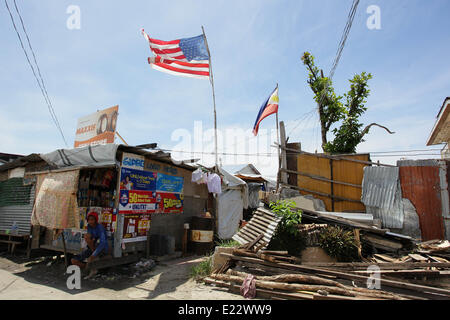 Tacloban, Philippines. 11th June, 2014. An American and Philippine flag is seen waving in Tacloban City on June 11, 2014. On November 8, 2013, Haiyan, one of the most powerful typhoon to ever hit land, ravaged Eastern Visayas leaving thousands dead and homeless. Government estimates 16 million people to have been affected by the typhoon, with 6,300 reported dead and thousands more missing. Housing and livelihood are among the serious challenges in the rehabilitation process in Haiyan-affected areas seven months after the disaster. © Mark Cristino/NurPhoto/ZUMAPRESS.com/Alamy Live News Stock Photo