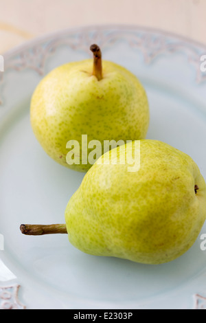 Two pears photographed in natural light on an antique plate. Stock Photo