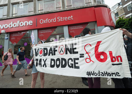 Oxford Street, London, UK. 14th June 2014. Activists from UK Uncut, Focus E15 & DPAC transformed the entrance to a Vodafone in Oxford shop Street, London, into a party with balloons, parachute children's games, Twister and a creche. The protest is in response to the retailer's alleged corporation tax avoidance since 2011 and the owing of £6bn in taxes stemming from 2000. Credit:  Lee Thomas/Alamy Live News