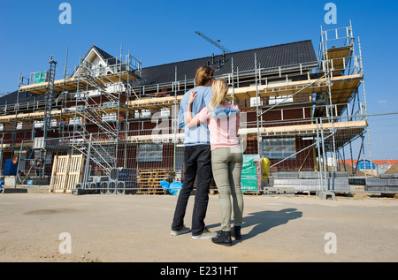 Young couple looking at newly built houses on construction site Stock Photo