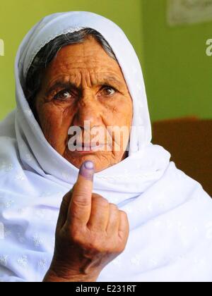 Kabul, Afghanistan. 14th June, 2014. An Afghan woman shows her inked finger after casting her vote at a polling center in Kabul, Afghanistan, on June 14, 2014. Voting for the country's next president began on Saturday morning and the final results will be announced on July 22. Credit:  Omid/Xinhua/Alamy Live News Stock Photo