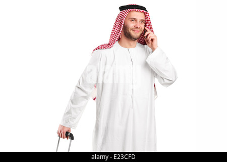 Arabic sheik talking on phone and carrying a luggage Stock Photo
