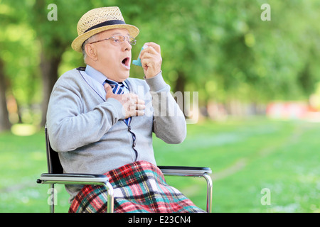 Senior man having an asthma attack in a park Stock Photo
