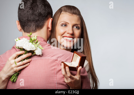 couple in love holding a bouquet of flowers. The concept of Valentine's Day. Engagement ring for a marriage proposal Stock Photo