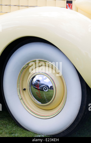 Front wing and wheel of a V8 Cadillac with a reflection of a hotrod in the wheel Stock Photo