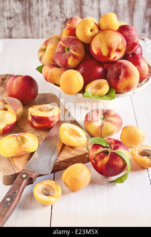 Ripe apricots, nectarines and saturn peaches on ceramic holder. Selective focus. Stock Photo
