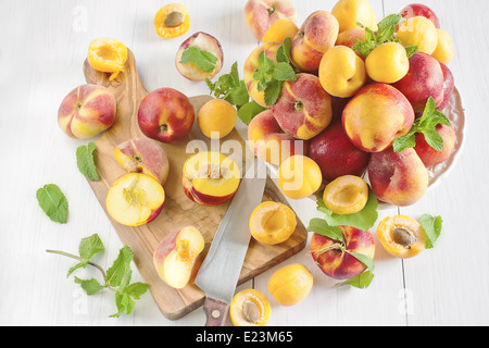 Ripe apricots, nectarines and saturn peaches on ceramic holder. Selective focus. Stock Photo
