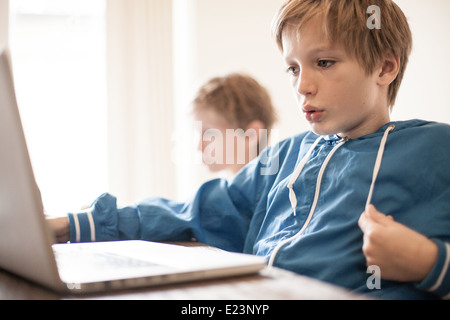 Two boys at home using laptop computers Stock Photo