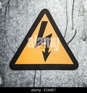 High voltage triangle sign mounted on gray metal wall Stock Photo