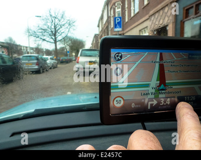 driver in car adjusts his gps system by hand Stock Photo