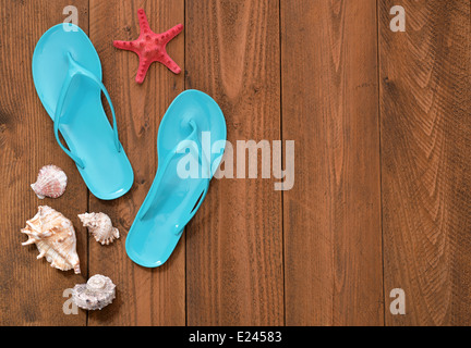 Vacation Concept. Blue Flip-flops with red starfish on wooden background, top view Stock Photo