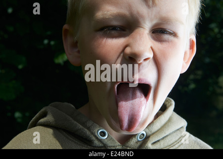 Silly young child blond boy gruesomely grimacing for camera Stock Photo