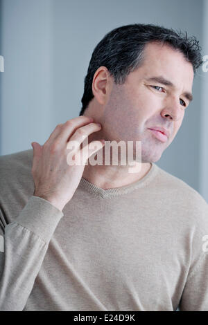 Itching in a man Stock Photo