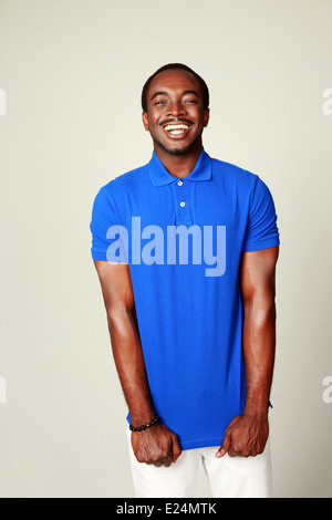 Laughing african man in blue t-shirt standing over white background Stock Photo