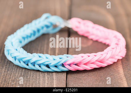 Two color rubber bracelet over a wooden background Stock Photo