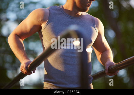 Young man training on sport equipment outside Stock Photo