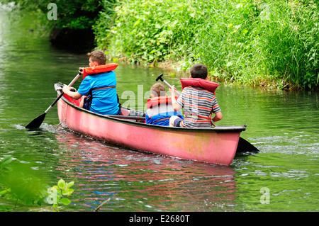 Three young boys learning to canoe. Stock Photo