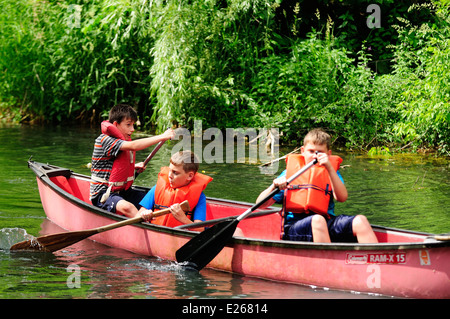 Three young boys learning to canoe. Stock Photo