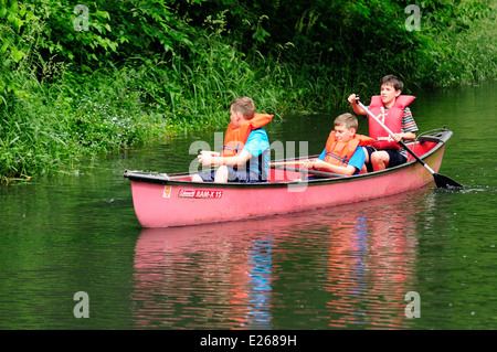 Three young boys learning to canoe. Stock Photo