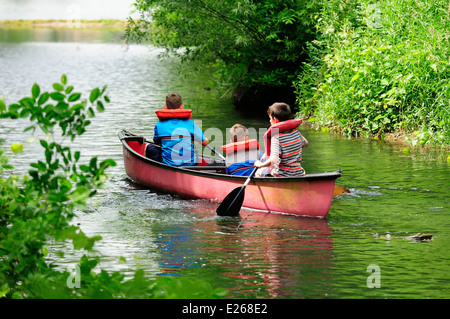 Three young boys learning to canoe. Stock Photo