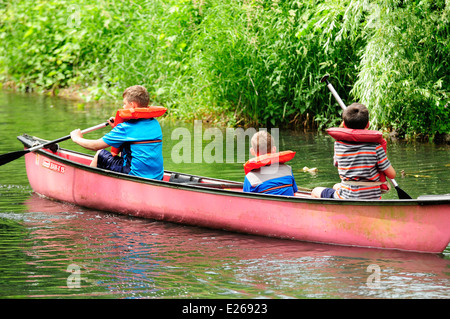 Three young boys learning to canoe. Stock Photo