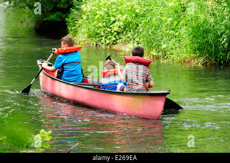 Three young boys learning to canoe. Stock Photo