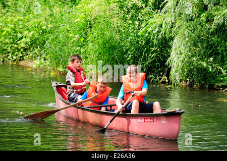 Three young boys learning to canoe. Stock Photo