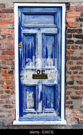 Worn blue and white door and a brick wall. Number 5 and 20B. Stock Photo