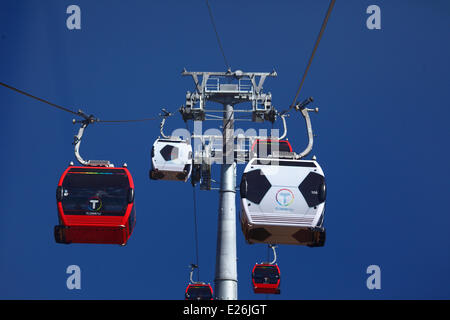 La Paz, Bolivia. 16th June, 2014. Gondolas in the form of a football travel on the new cable car / gondola lift system linking La Paz and El Alto. Several gondolas have been changed to a football design to celebrate the 2014 World Cup currently being held in Brazil. The first of three cable car lines was inaugurated on 30th May 2014, in total they will form the longest and highest urban cable car system in the world. Credit:  James Brunker / Alamy Live News Stock Photo