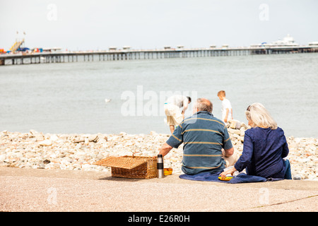 Mature couple having picnic on Llandudno promenade steps, enjoying the sea view Stock Photo
