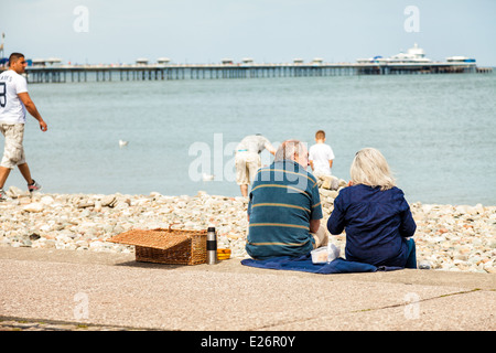 Mature couple having picnic on Llandudno promenade steps, enjoying the sea view Stock Photo