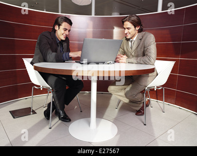 Business meeting - two businessmen in suits working together in boardroom Stock Photo