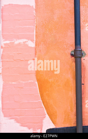 A drain pipe on an external wall with painted shades of color Stock Photo