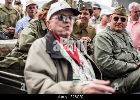 St Mere Eglise, Normandy, France. 6th June, 2014. Reenactors drive an American veteran of the Normandy campaign during a parade in St Mere Eglise, Normandy, France, June 6, 2014. Thousands of people visited the region to commemorate the invasion's anniversary. This year marks the 70th anniversary of the landings that liberated France and ended the war in Europe. © Bill Putnam/ZUMA Wire/ZUMAPRESS.com/Alamy Live News Stock Photo