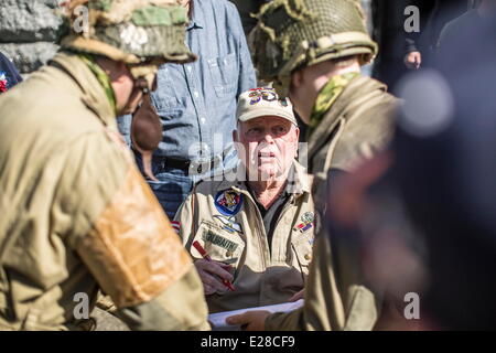 Jun 7, 2014 - Le Cambe, Normandy, France - William Galbraith, an American veteran of World War 2, talks with reenacators at the German cemetery in Le Cambe, Normandy, France, June 7, 2014. Galbraith, from San Diego, Calif., jumped into Normandy on June 6, 1944, with the 506th Parachute Infantry Regiment. Over 21,000 German servicemembers killed in Normandy between June 6 and August 20, 1944, are buried at the ceremtery. Thousands of people visited the region to commemorate the invasion's anniversary. This year marks the 70th anniversary of the landings that liberated France and ended the war i Stock Photo