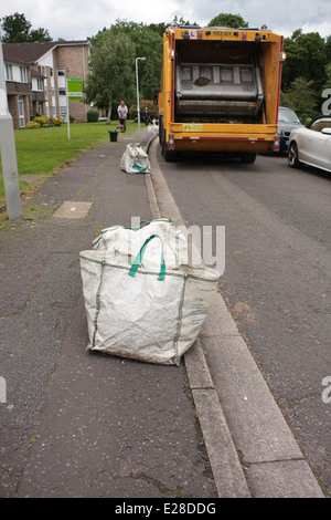 Garden waste in recycling bags at the roadside waiting to be collected Stock Photo
