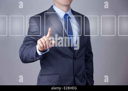 Businessman pushing on a touch screen interface Stock Photo