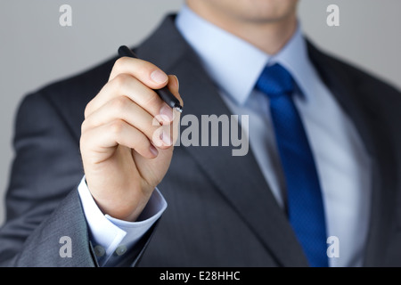 Business man writing something on glass board with marker close-up Stock Photo