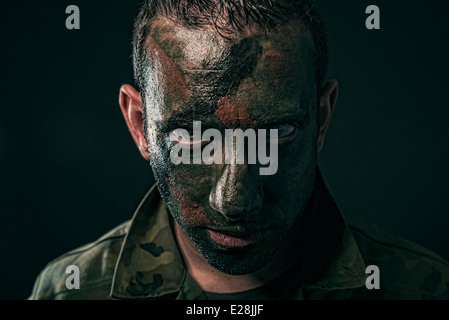 Spanish military with camouflage paint on face on black background Stock Photo
