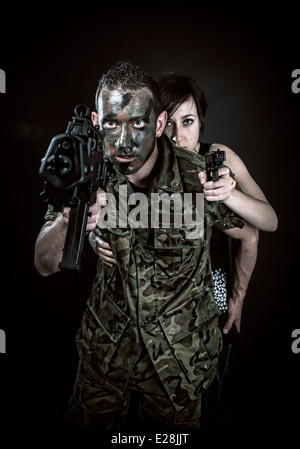 Spanish military with SMG and girl with gun on black background Stock Photo
