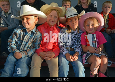 Portrait of 4 children in cowboy hats at the Jackson Hole rodeo in Wyoming. Stock Photo