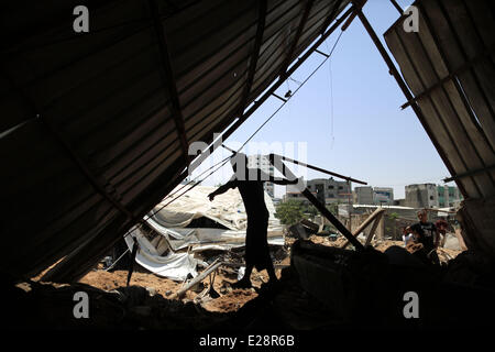 Gaza, Tuesday. 17th June, 2014. Palestinians inspect the rubble of a destroyed metal workshop after it was hit by an Israeli airstrike in Gaza City, early Tuesday, June 17, 2014. Israeli warplanes struck a terror activity site and two weapon storage facilities, in the southern, central Gaza Strip, and an arms manufacturing facility in the northern Gaza, the Army spokesman said. Credit:  Wissam Nassar/Xinhua/Alamy Live News Stock Photo
