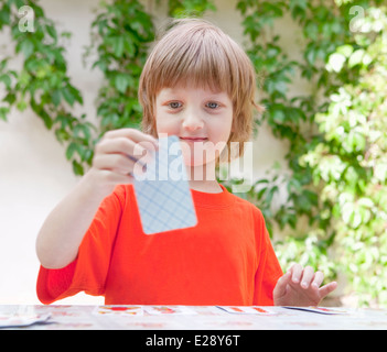 Boy with Blond Hair Playing Cards Outdoors