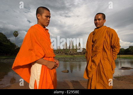 Two Buddhist monks on the outside of the Temple of Angkor Wat. Angkor Wat, in its beauty and state of preservation, is unrivaled Stock Photo