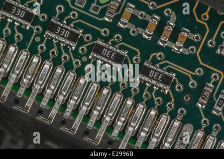 Macro photo of surface-mounted components on PC motherboard. Edge connector contacts also visible. See 'description' for focus. Stock Photo