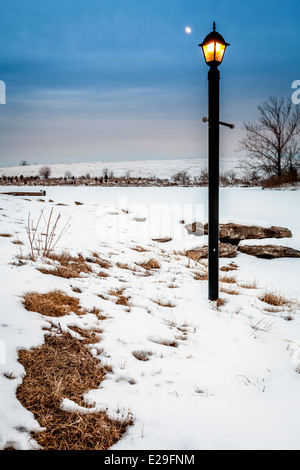 Moon rising over a frozen lake Stock Photo