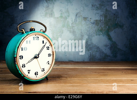 Retro alarm clock on wooden table on grunge background Stock Photo