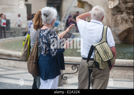 Rome Italy - Elderly tourists by  a fountain in Piazza Navona with digital tablet Stock Photo